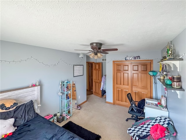 bedroom featuring light carpet, ceiling fan, and a textured ceiling