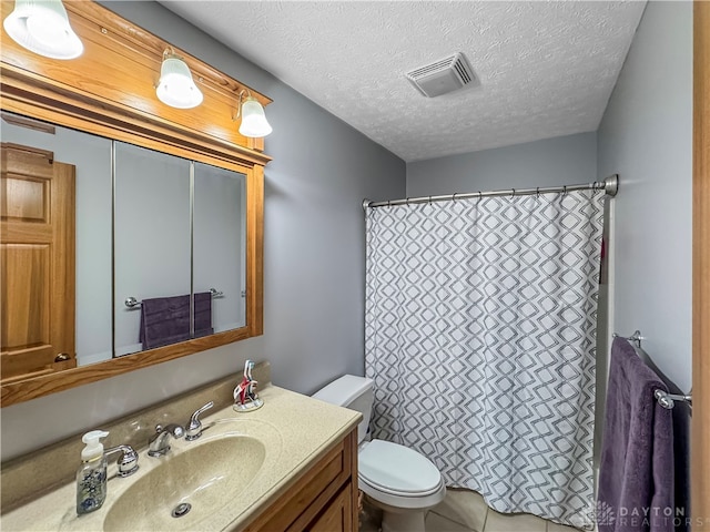 bathroom with vanity, toilet, and a textured ceiling