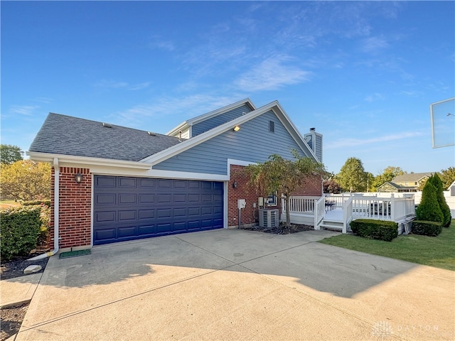 view of side of home with a garage and central AC