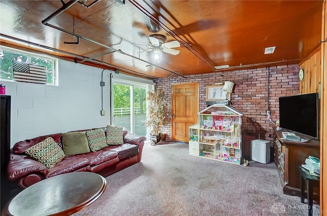 living room with carpet floors, brick wall, and ceiling fan