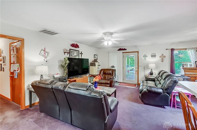 living room with a wealth of natural light, carpet, and ceiling fan