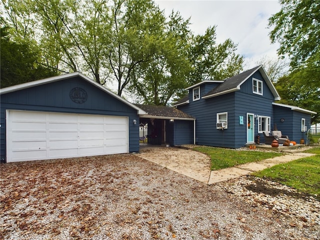 view of front of property with a garage and cooling unit