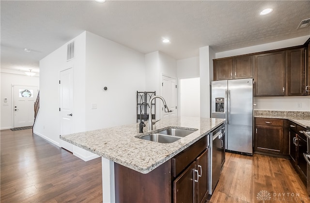 kitchen featuring a kitchen island with sink, stainless steel appliances, dark hardwood / wood-style floors, and sink