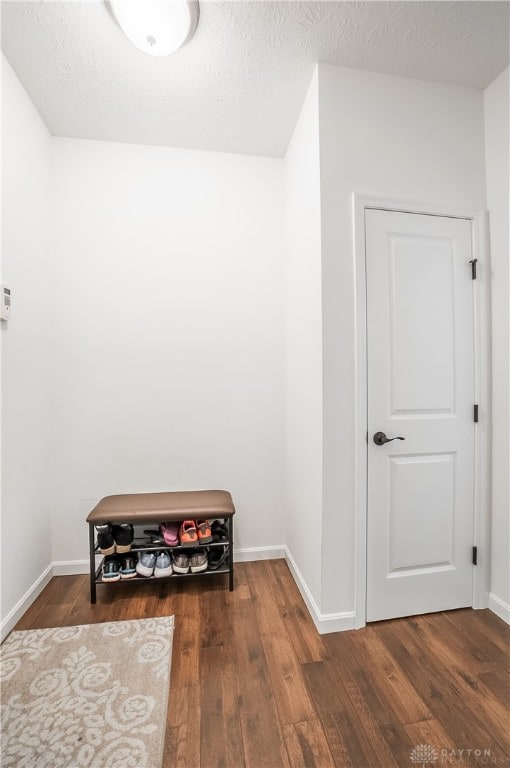 interior space with a textured ceiling and dark hardwood / wood-style floors