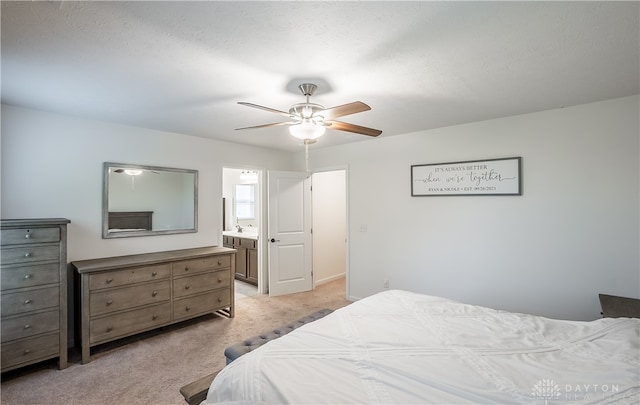 bedroom with a textured ceiling, sink, light carpet, connected bathroom, and ceiling fan