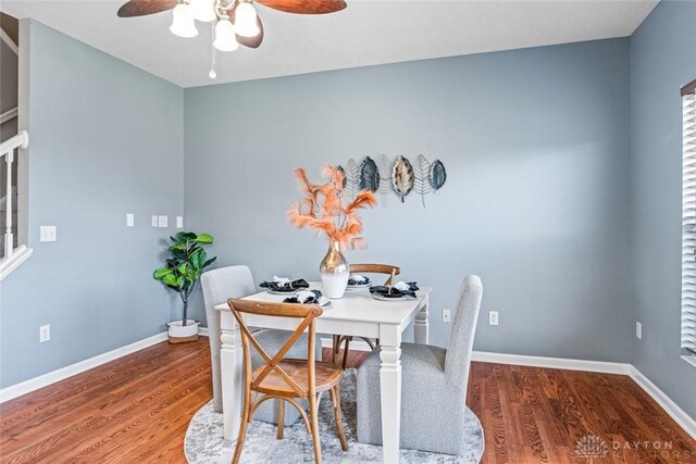 dining area with wood-type flooring and ceiling fan