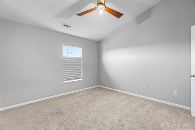 carpeted empty room featuring ceiling fan and lofted ceiling