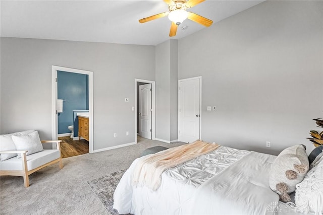 carpeted bedroom with ensuite bathroom, vaulted ceiling, and ceiling fan