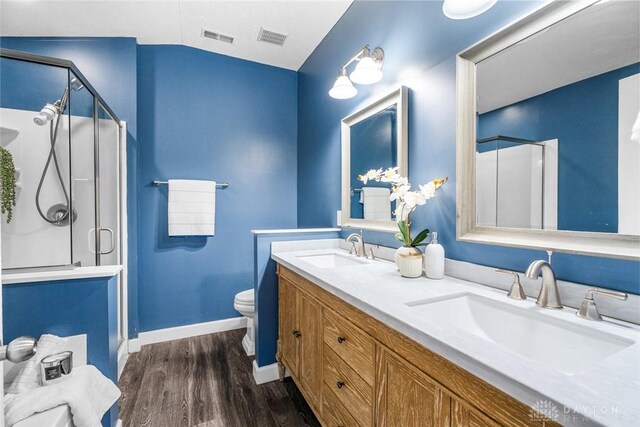 bathroom with an enclosed shower, vaulted ceiling, toilet, vanity, and hardwood / wood-style flooring