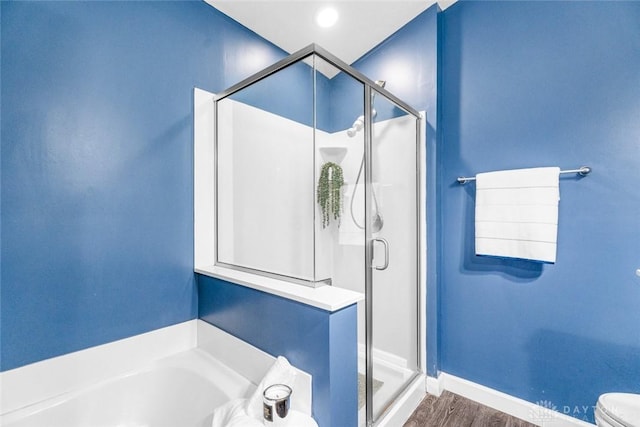 bathroom featuring toilet, hardwood / wood-style flooring, and separate shower and tub