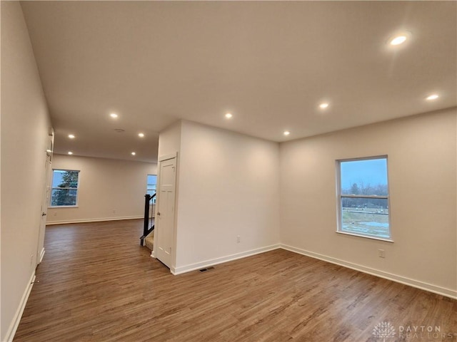 unfurnished room featuring plenty of natural light and dark hardwood / wood-style flooring