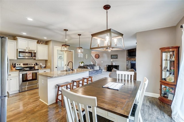 dining area with light hardwood / wood-style floors, sink, and a fireplace