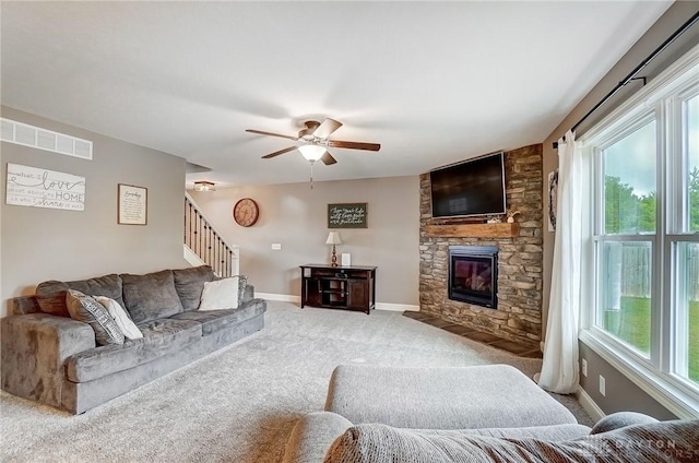 living room featuring carpet flooring, ceiling fan, plenty of natural light, and a fireplace