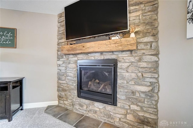 room details featuring carpet flooring and a stone fireplace