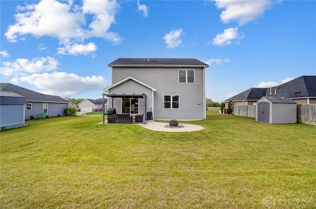 rear view of property featuring a patio area, a yard, a shed, and an outdoor fire pit