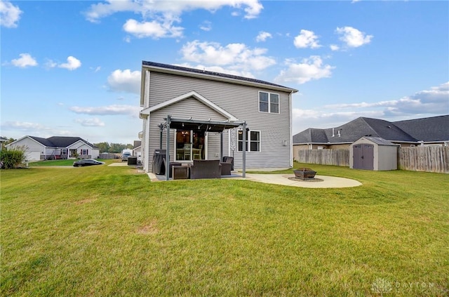 back of house featuring a fire pit, a storage unit, a patio area, and a lawn