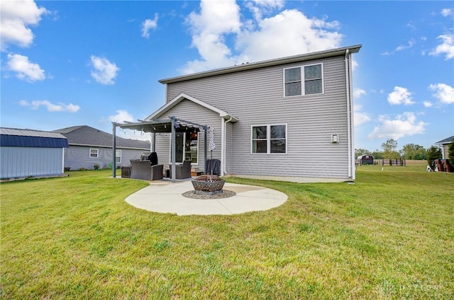 back of house featuring a lawn, a patio, and an outdoor fire pit