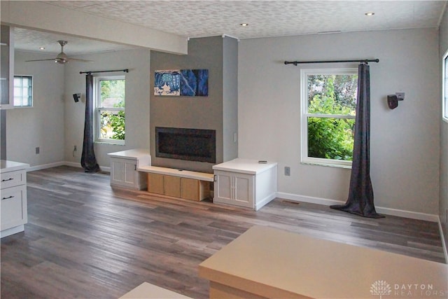 unfurnished living room with ceiling fan, hardwood / wood-style floors, and a textured ceiling