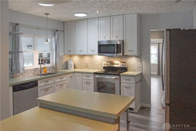 kitchen featuring white cabinets, appliances with stainless steel finishes, dark hardwood / wood-style flooring, and sink