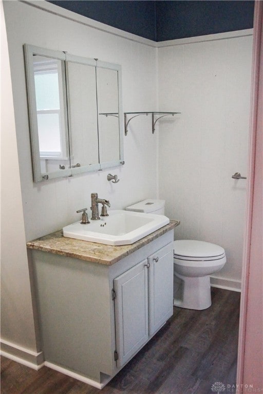 bathroom with hardwood / wood-style floors, vanity, and toilet