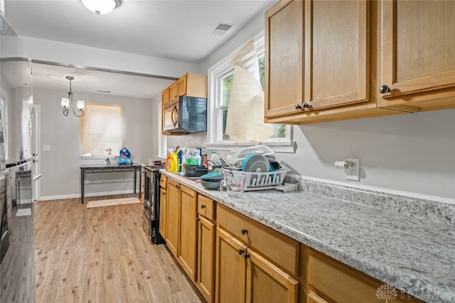 kitchen with light hardwood / wood-style floors, sink, a notable chandelier, range with electric cooktop, and light stone countertops