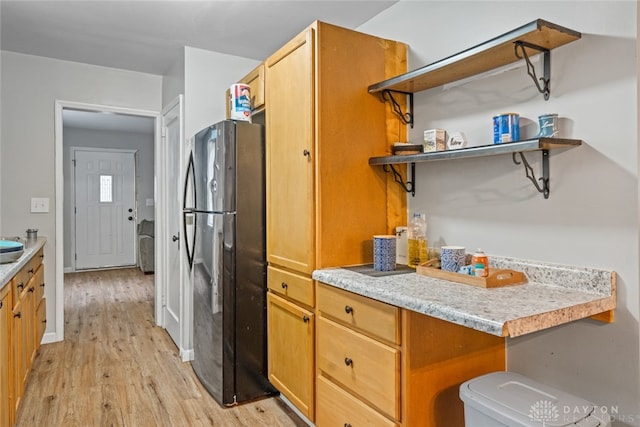 kitchen featuring light wood-type flooring and black refrigerator