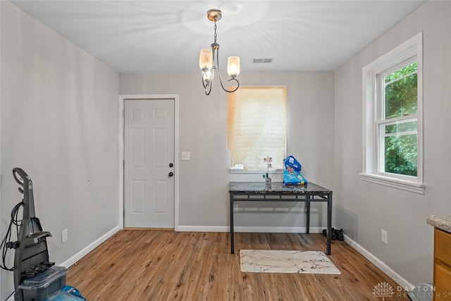 miscellaneous room featuring light hardwood / wood-style floors and an inviting chandelier