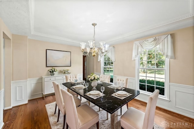 dining space with hardwood / wood-style flooring and a notable chandelier