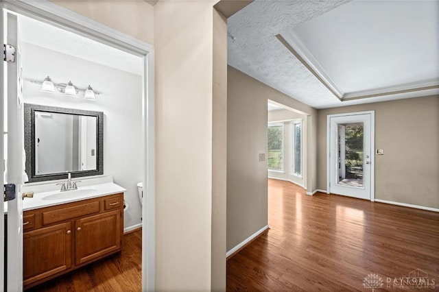 bathroom featuring a textured ceiling, hardwood / wood-style floors, vanity, and toilet