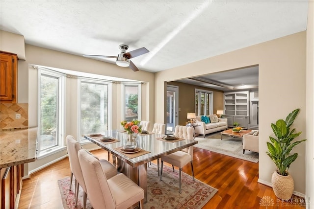 dining area featuring ceiling fan, a textured ceiling, and light wood-type flooring