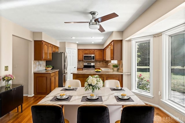 dining room featuring ceiling fan, light wood-type flooring, and sink