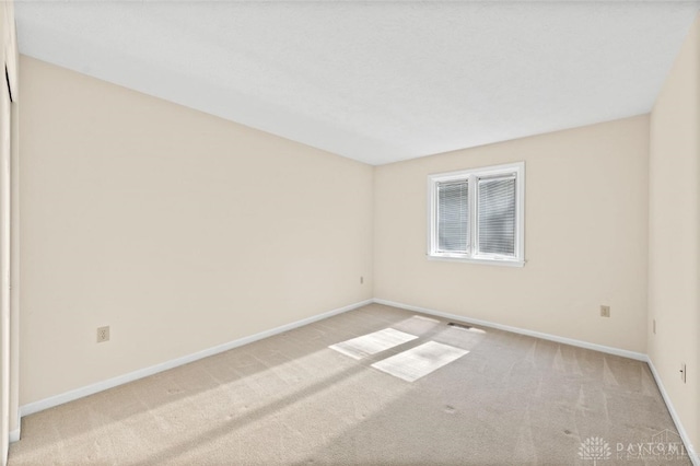 spare room featuring light colored carpet