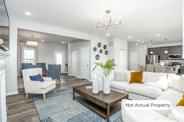 living room with dark wood-type flooring and a notable chandelier