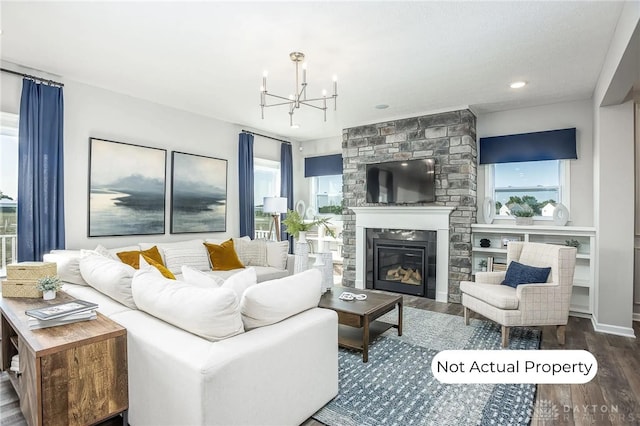 living room featuring hardwood / wood-style floors, a fireplace, and a chandelier