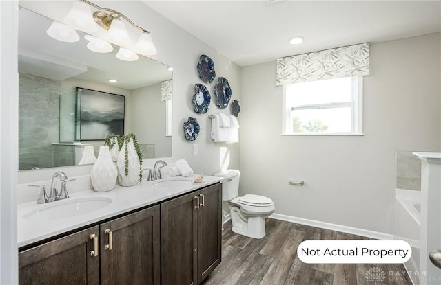 bathroom with vanity, hardwood / wood-style floors, a bathing tub, and toilet