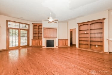 unfurnished living room featuring ceiling fan and wood-type flooring