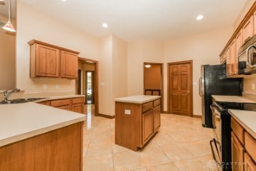 kitchen featuring light tile patterned floors, sink, electric range, and a center island