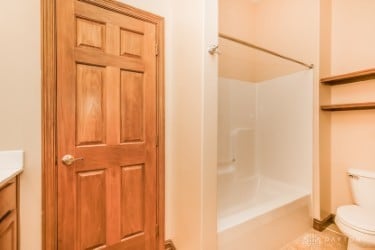 full bathroom with tile patterned flooring,  shower combination, vanity, and toilet