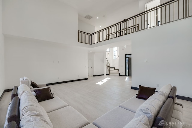 living room featuring light hardwood / wood-style flooring and a high ceiling