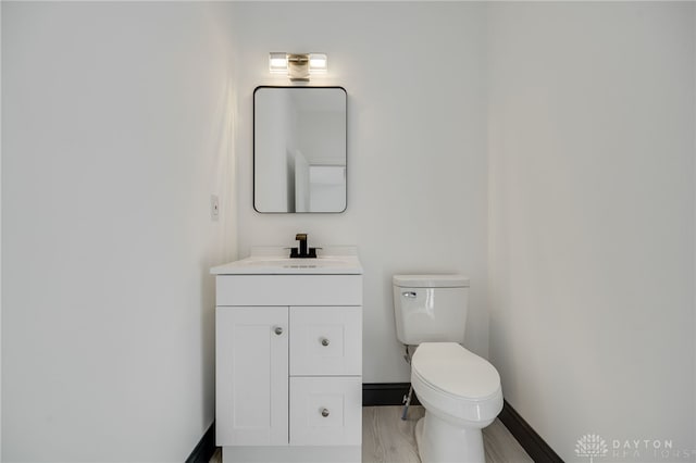 bathroom featuring toilet, vanity, and wood-type flooring