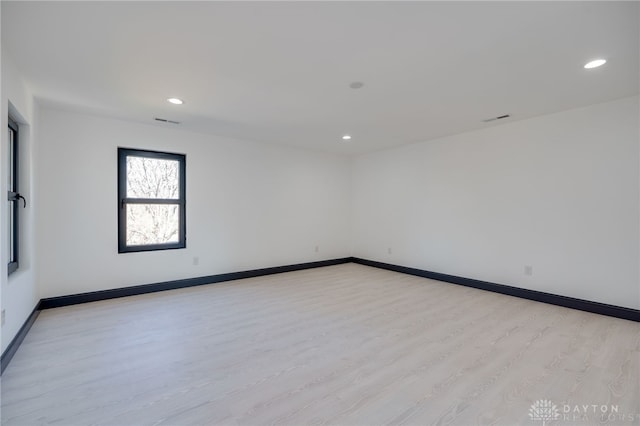 empty room with light hardwood / wood-style flooring