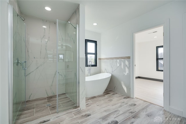 bathroom featuring independent shower and bath and plenty of natural light