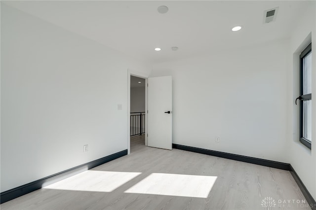 empty room with light hardwood / wood-style flooring and plenty of natural light