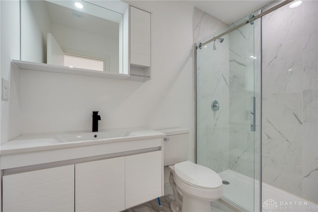 bathroom with walk in shower, vanity, and toilet