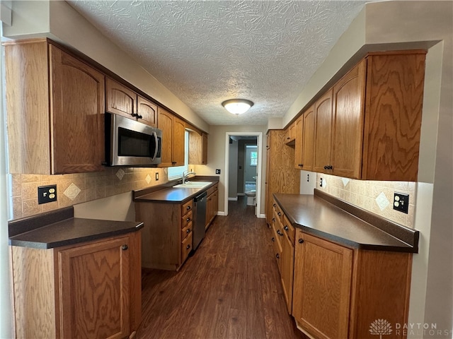 kitchen featuring a textured ceiling, stainless steel appliances, dark hardwood / wood-style flooring, and tasteful backsplash