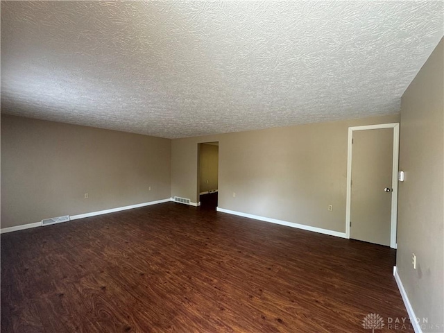 4130 Chalfant Dr, Medway, OH 45341 - unfurnished room with dark wood-type flooring, visible vents, a textured ceiling, and baseboards