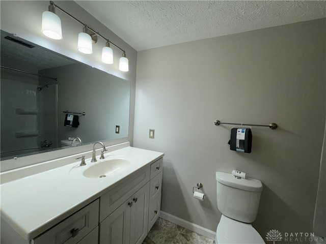 bathroom featuring vanity, toilet, and a textured ceiling