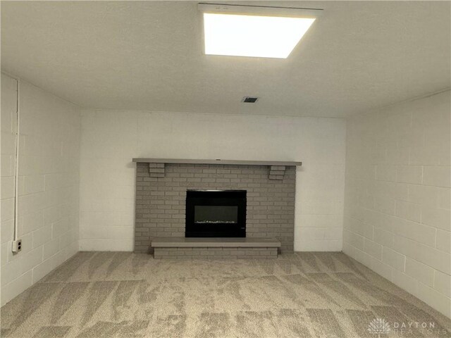 4130 Chalfant Dr, Medway, OH 45341 - unfurnished living room featuring visible vents, a fireplace, carpet, and concrete block wall