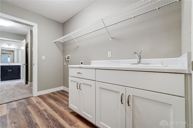 washroom featuring hookup for an electric dryer, hookup for a washing machine, cabinets, sink, and hardwood / wood-style floors