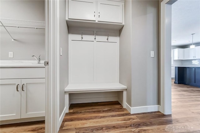 mudroom with hardwood / wood-style floors and sink